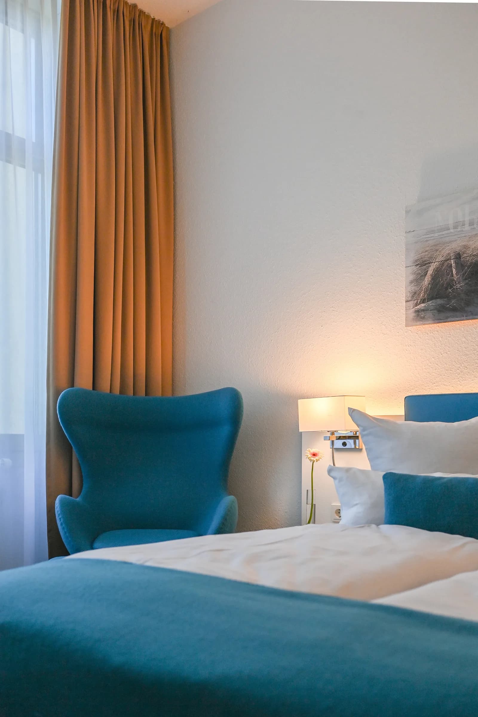 Chambre simple avec fauteuil près de la fenêtre
