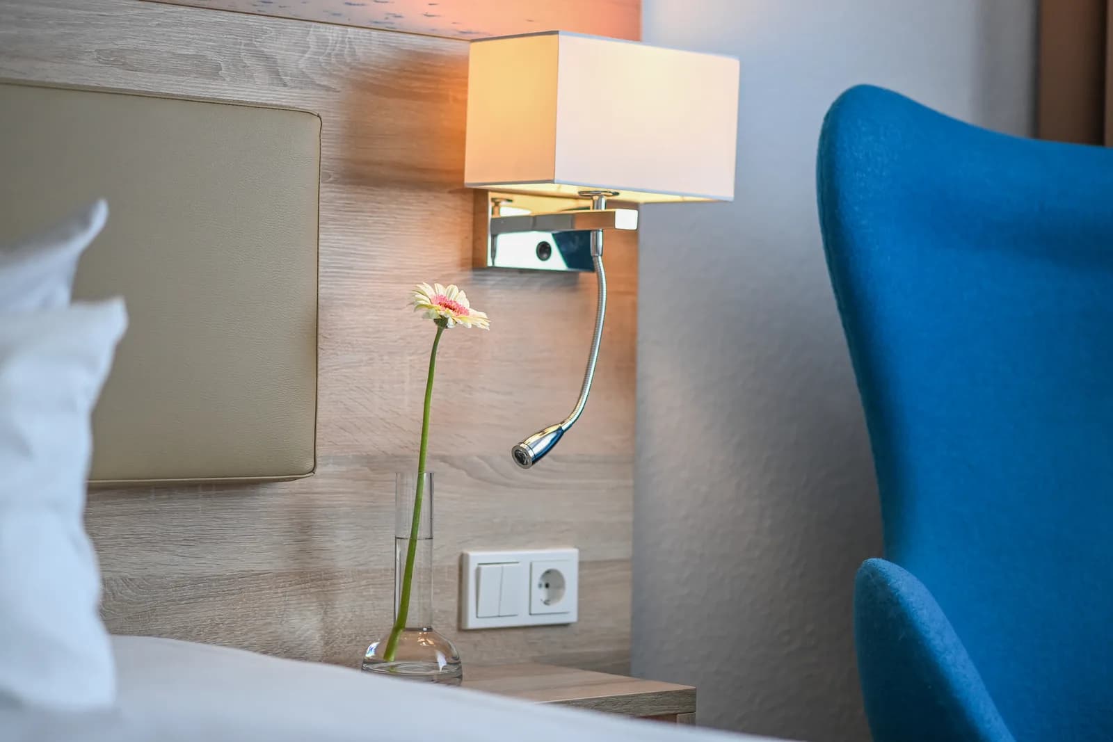 Reading lamp and flower by the bed