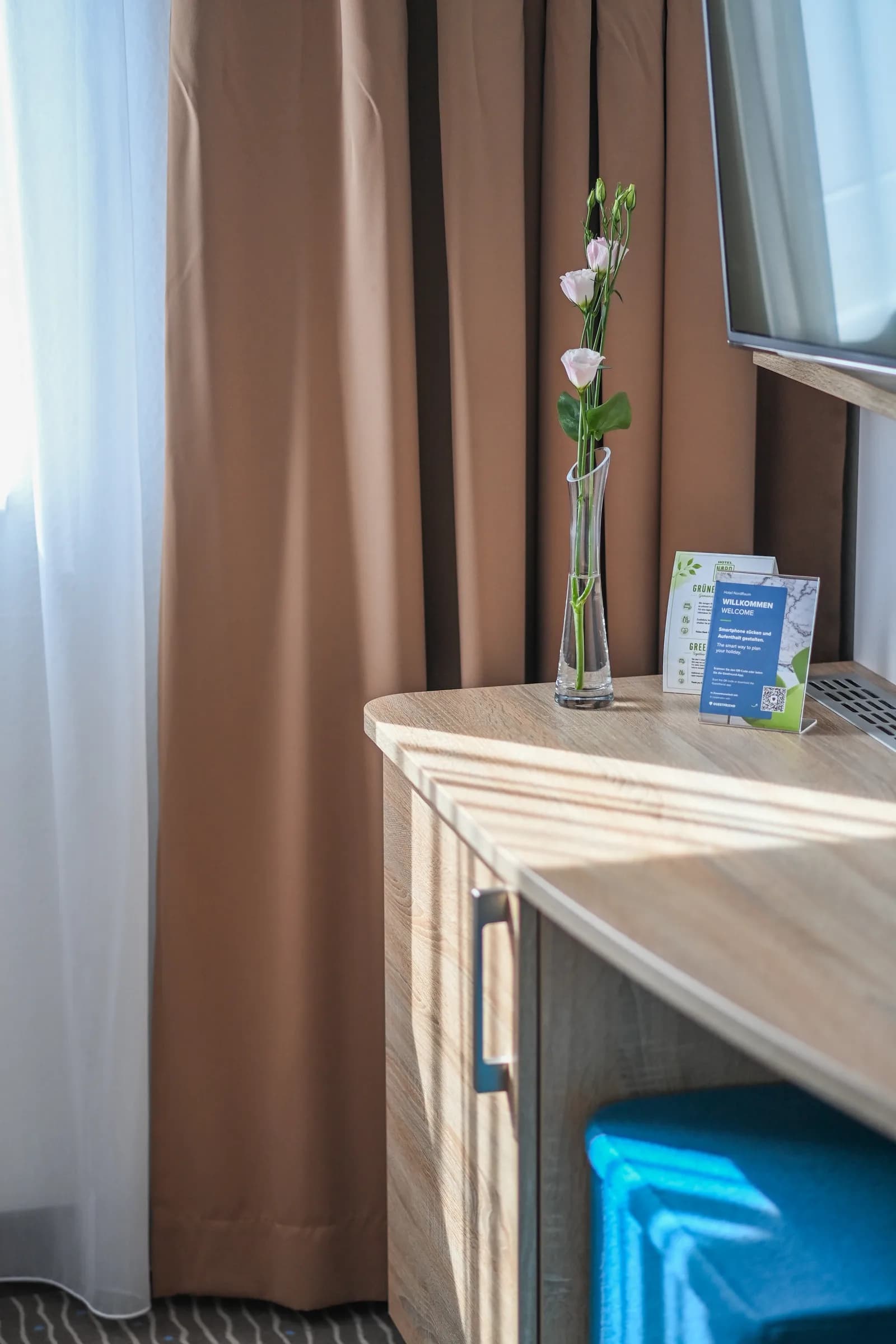 Bureau avec vase de fleurs et informations sur l'hôtel