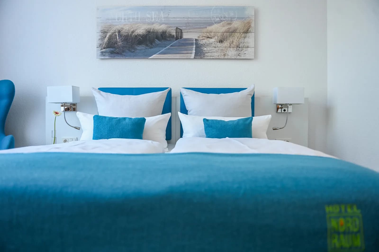 Doppelbett mit zwei blauen Kopfteilen und Tagesdecke
